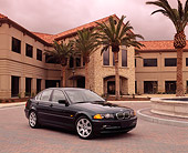 AUT 01 RK0078 03
1999 BMW 328i Green 3/4 Front View On Pavement By Building And Palm Trees Filtered