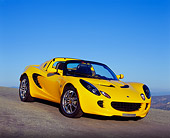 AUT 04 RK0116 02
2003 Lotus Elise Yellow 3/4 Front View On Pavement Hill Blue Sky