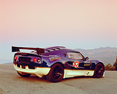 AUT 04 RK0127 05
2001 Lotus Elise Motorsport Race Car Blue 3/4 Rear View On Pavement Hill Mountains Background