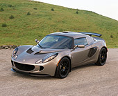 AUT 04 RK0138 01
2006 Lotus Exige Silver 3/4 Front View On Pavement By Grass Hills Blue Sky