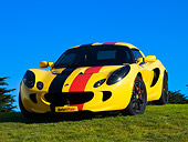 AUT 04 RK0150 01
2005 Lotus Elise Yellow Sunburst Red And Black Stripes Front 3/4 View On Grass Blue Sky