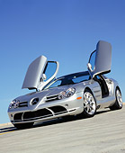 AUT 05 RK0429 11
2005 Mercedes-Benz SLR McLaren Silver Low 3/4 Front View Butterfly Doors On Pavement Blue Sky