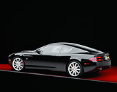 AUT 06 RK0068 05
2005 Aston Martin DB9 Coupe Black 3/4 Rear View On Red Floor Gray Line Studio