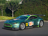 AUT 13 RK0270 01
2007 Aston Martin DBR9 Race Car 007 Green 3/4 Front View On Pavement By Shrubs