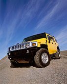 AUT 15 RK0621 19
2003 Hummer H2 Yellow 3/4 Front Low View Wide Angle Shot On Gravel Blue Sky