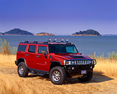 AUT 15 RK0725 02
2003 Hummer H2 Orange 3/4 Front View On Dry Grass By Water