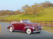 AUT 19 RK0780 01
1939 Plymouth P8 Convertible Dark Cranberry 3/4 Front View On Pavement By Fence And Grassy Hill