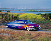 AUT 20 RK0060 02
1949 Mercury Custom Street Rod Blue With Flames 3/4 Side View By Bushes At Dusk
