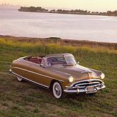 AUT 21 RK0853 05
1953 Hudson Hornet Convertible Gold Overhead Front 3/4 View On Dirt Headlights On By Water
