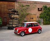 AUT 21 RK1593 07
1959 Mini Cooper Red And White 3/4 Side View On Gravel By Water Well And Brick Building