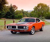 AUT 22 BK0081 01
1973 Dodge Charger 440 Magnum R/T Orange With Black Stripe 3/4 Front View On Pavement By Grass And Trees