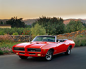 AUT 22 RK0479 04
1969 GTO Judge Convertible Red 3/4 Front View On Pavement By Rock Fence Flowers And Trees