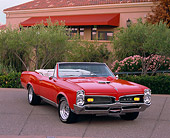 AUT 22 RK1566 01
1967 Pontiac GTO Convertible Red 3/4 Front View By Trees Bushes And Building