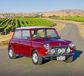 AUT 23 BK0054 01
1975 Morris Mini Cooper Red 3/4 Front View On Road By Crops