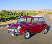 AUT 23 BK0055 01
1975 Morris Mini Cooper Red 3/4 Front View On Road By Crops
