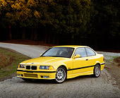 AUT 25 RK0429 02
1995 BMW M3 Yellow 3/4 Front View On Pavement By Trees At Dusk