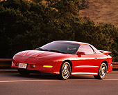 AUT 25 RK0842 11
1993 Pontiac Firebird Trans Am Red 3/4 Front View On Road By Bushes