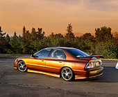 AUT 25 RK1260 06
1996 Honda Accord DX Custom Bronze 3/4 Rear View On Pavement Trees Background