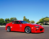 AUT 25 RK1348 03
1994 Toyota Supra Red Custom Low 3/4 Side View On Pavement Trees Blue Sky