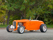 AUT 26 RK2861 01
1932 Ford Hi-Boy Roadster Hot Rod Orange 3/4 Front View On Pavement By Trees