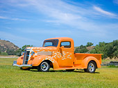 AUT 26 RK3046 01
1937 GMC Pickup Truck Orange With White Flames 3/4 Side View On Grass By Hills