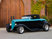 AUT 26 RK1209 01
1932 Ford Roadster Hot Rod Black And Turquoise Front 3/4 View On Pavement By Brick Building Wooden Door