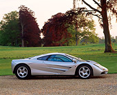 AUT 28 RK0039 01
McLaren F-1 Silver Profile On Gravel By Grass And Trees