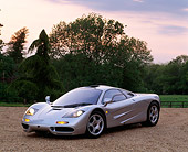 AUT 28 RK0041 01
McLaren F-1 Silver 3/4 Front View On Gravel With Lights On By Trees At Dusk