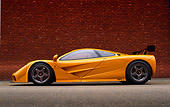 AUT 28 RK0057 07
1996 McLaren F1 LM Orange Profile On Pavement By Brick Wall