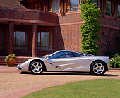 AUT 28 RK0074 02
McLaren F1 Silver Profile On Driveway By Grass And Brick Building