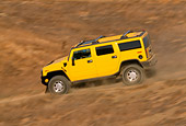AUT 29 RK0621 11
2003 Hummer H2 Yellow 3/4 Rear View On Dirt Hill Road In Motion