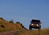 AUT 29 RK0701 02
2004 Jeep Wrangler Rubicon Light Khaki 3/4 Front View On Dirt Trail