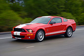 AUT 29 RK1259 01
2007 Ford Shelby Mustang GT500 Coupe Red And White 3/4 Side View On Road In Motion