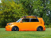 AUT 43 RK0335 01
2008 Scion xB Orange 3/4 Front View By Trees