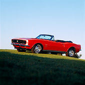 CAM 02 RK0007 03
1967 Chevrolet SS Camaro Convertible Red 3/4 Side View On Grass Hill Blue Sky