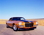 CAM 04 RK0071 02
1973 Chevrolet Camaro Gold Black Stripe Low 3/4 Front View On Road Blue Sky