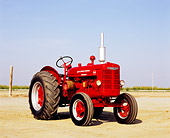 TRA 01 RK0089 01
1947 McCormick Deering W-4 Standard Red Tractor 3/4 Front View On Dirt Blue Sky