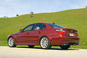 AUT 01 RK0248 01
2006 BMW M5 Burgundy 3/4 Rear View On Pavement By Grass Hills