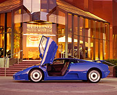 AUT 02 RK0005 03
1994 Bugatti EB110 GT Coupe Blue Profile Shot Doors Open By Museum At Dusk