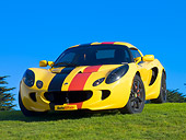 AUT 04 RK0150 01
2005 Lotus Elise Yellow Sunburst Red And Black Stripes Front 3/4 View On Grass Blue Sky