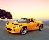 AUT 04 RK0118 02
2003 Lotus Elise Yellow 3/4 Side View On Pavement Hill By Tree