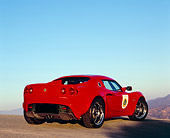 AUT 04 RK0124 02
2005 Lotus Elise Red 3/4 Low Rear View On Pavement Hill Blue Sky