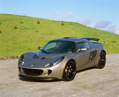 AUT 04 RK0134 02
2006 Lotus Exige Silver 3/4 Front View On Pavement By Grass Hills Blue Sky
