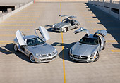 AUT 05 RK0660 01
2009 Mercedes-Benz McLaren SLR Stirling Moss, 1956 Mercedes-Benz 300 SL Gullwing Coupe And 2011 Mercedes-Benz SLS AMG Silver 3/4 Front View On Roof Of Parking Garage