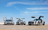 AUT 05 RK0661 01
2009 Mercedes-Benz McLaren SLR Stirling Moss Roadster, 1956 Mercedes-Benz 300 SL Gullwing Coupe And 2011 Mercedes-Benz SLS AMG Silver 3/4 Front View On Roof Of Parking Garage