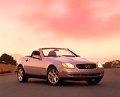 AUT 05 RK0036 03
1998 Mercedes SLK Kompressor Convertible Silver 3/4 Front On Road Lights On By Trees At Dusk