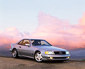 AUT 05 RK0074 04
1997 Silver 500SL Mercedes Sport 3/4 Front View On Pavement Headlights On At Dusk Purple Clouds