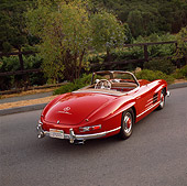 AUT 05 RK0149 03
1957 Mercedes-Benz 300SL Convertible Red 3/4 Rear View On Pavement Hill By Bushes