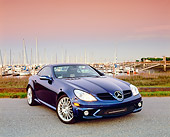 AUT 05 RK0423 01
2005 Mercedes SLK55 Roadster Blue 3/4 Front View On Pavement By Harbor Filtered