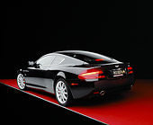 AUT 06 RK0063 01
2005 Aston Martin DB9 Coupe Black 3/4 Rear View On Red Floor Studio